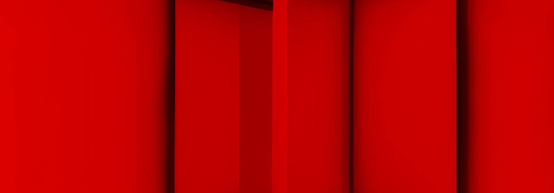 La imagen muestra un espacio abstracto y completamente rojo con formas geométricas.