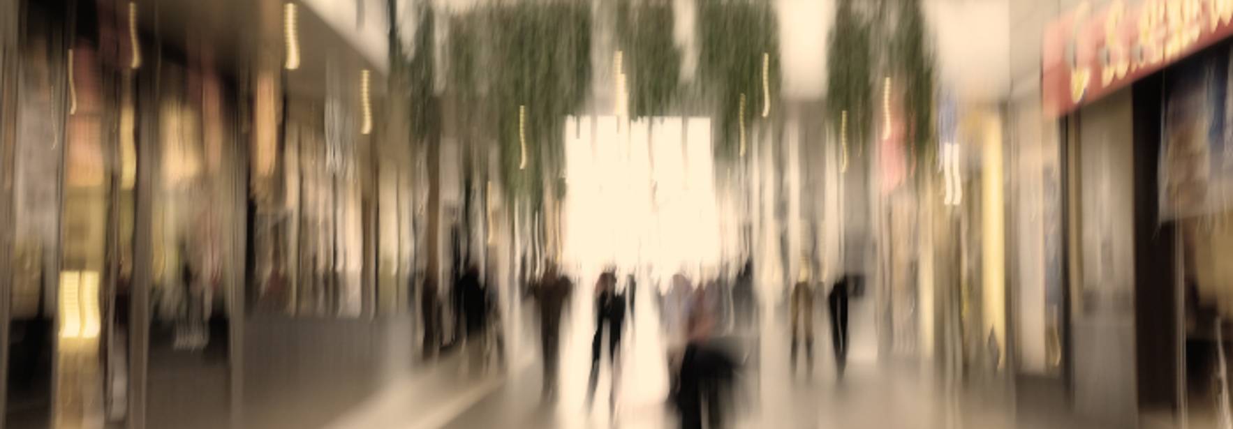 Una imagen desenfocada de un centro comercial con personas caminando.