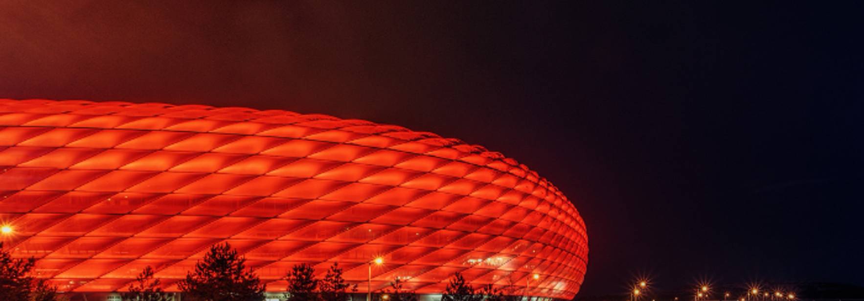 El estadio brilla intensamente en rojo durante la noche.