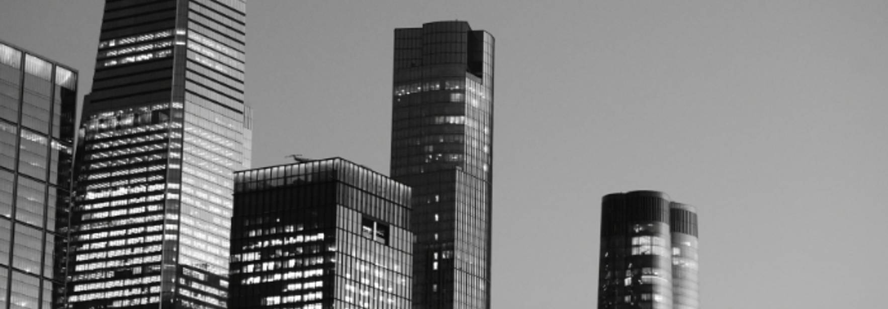 Una imagen en blanco y negro de rascacielos que se alzan en un horizonte urbano.