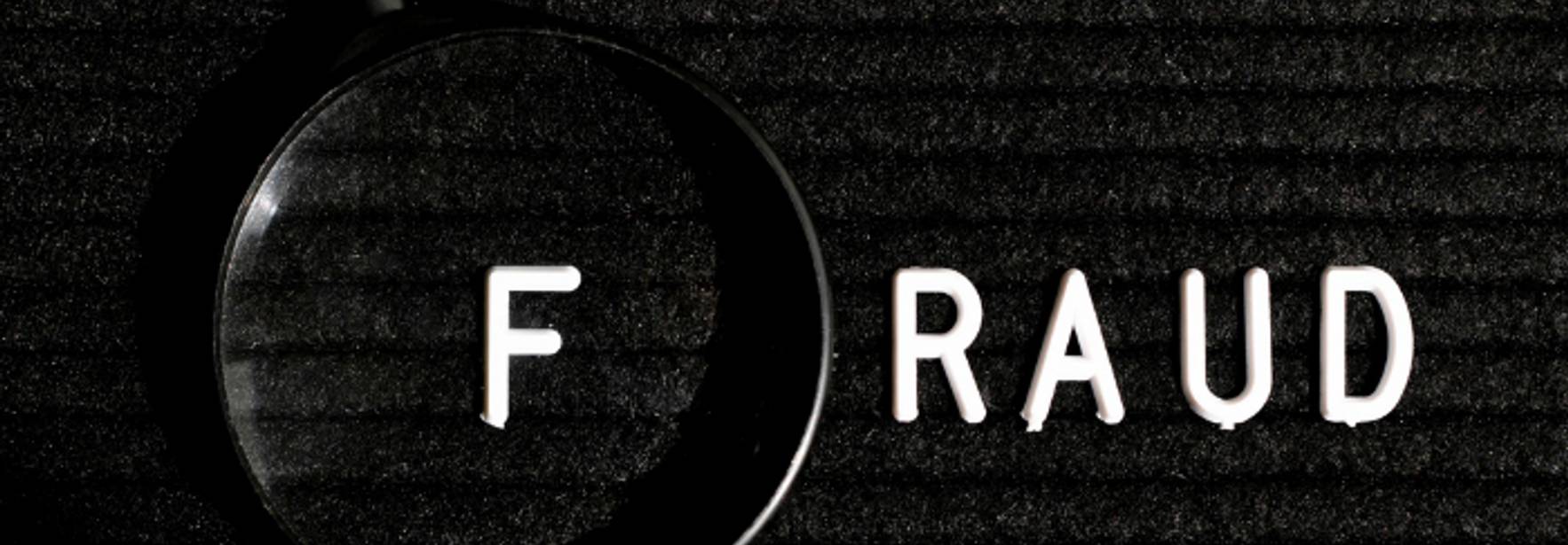 La imagen muestra la palabra 'FRAUD' con una lupa enfocando la letra 'F'.
