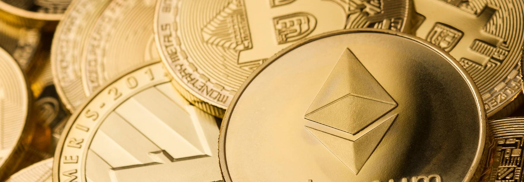La imagen muestra varias monedas de criptomonedas, destacando una moneda de Ethereum en el centro.