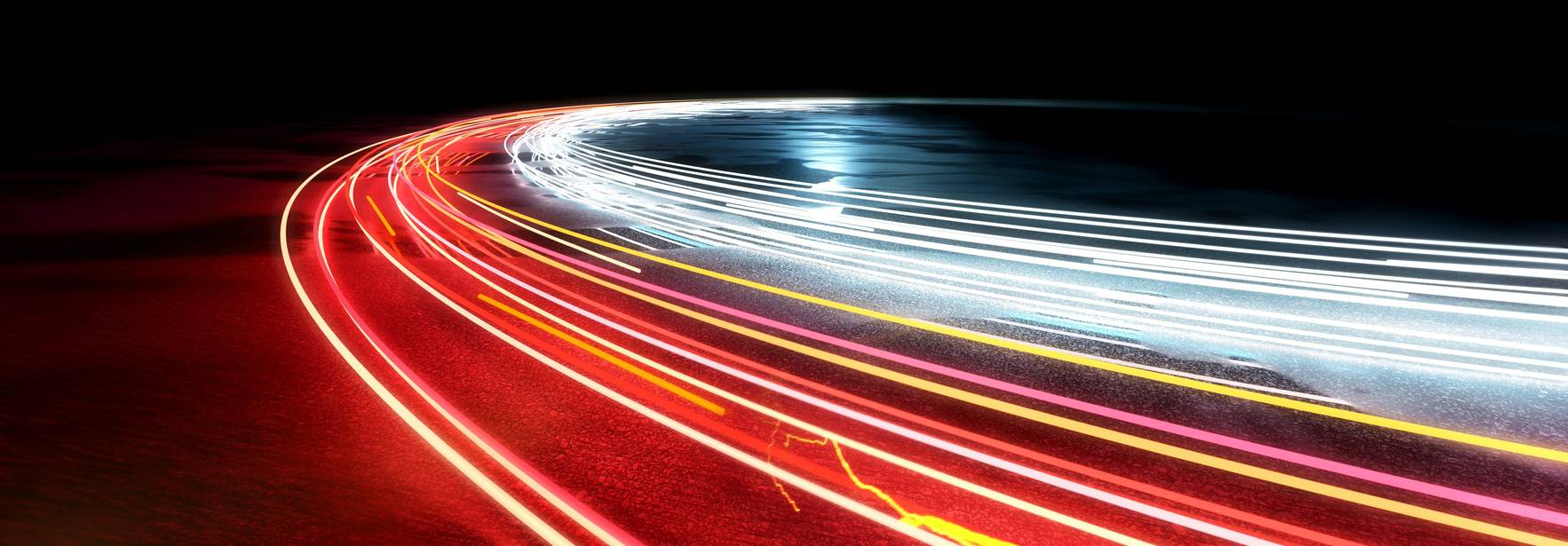 La imagen muestra trazos de luz en movimiento que crean un efecto dinámico en un fondo oscuro.