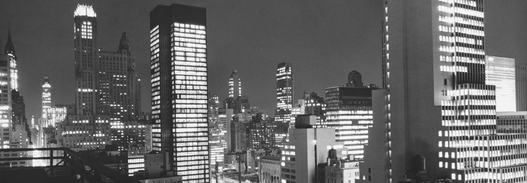 Una vista nocturna de un paisaje urbano con edificios iluminados en blanco y negro.