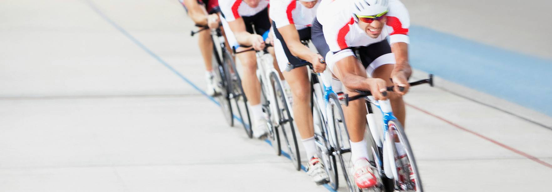 Un grupo de ciclistas compitiendo en una pista de velódromo.