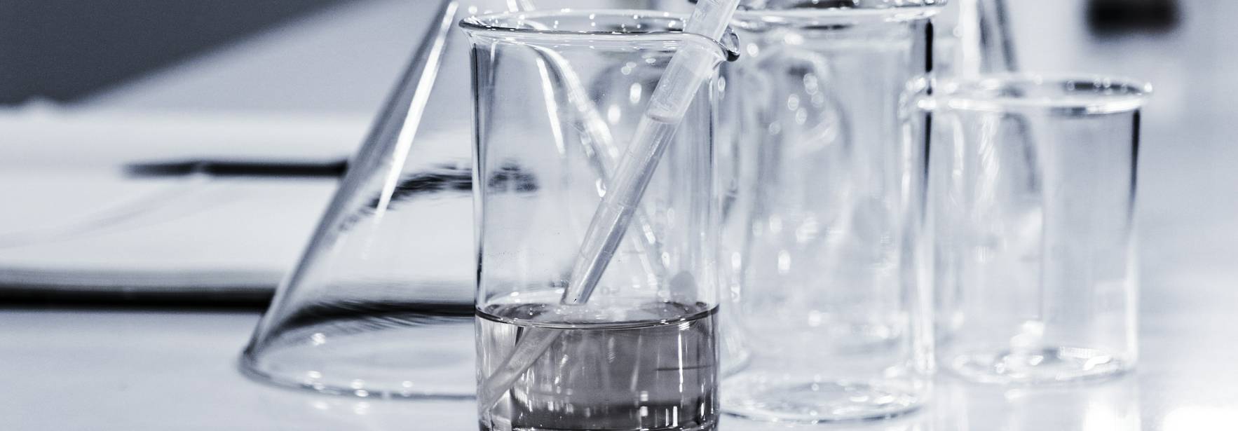 Utensilios de laboratorio de vidrio sobre una mesa.