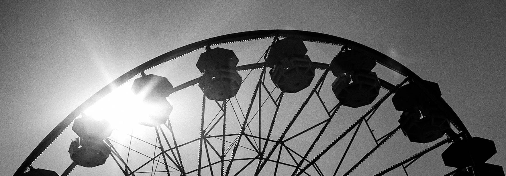 Una noria silhoueteada contra el sol en un cielo despejado.