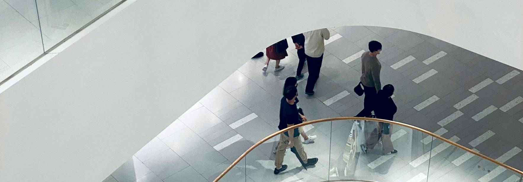 Vista desde arriba de un centro comercial con escaleras y personas caminando.