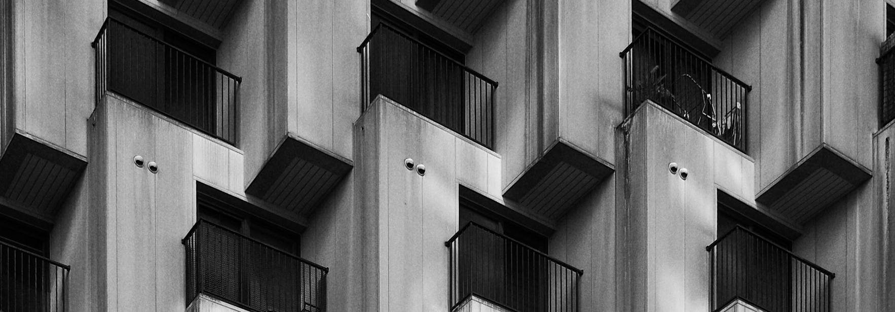 Una fachada de edificio con una serie de balcones en un patrón geométrico en blanco y negro.