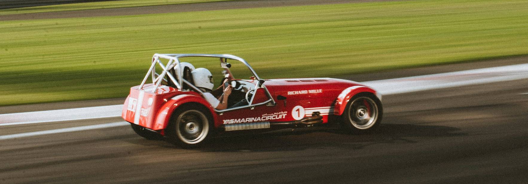 Un coche de carreras rojo se desplaza rápidamente por una pista.