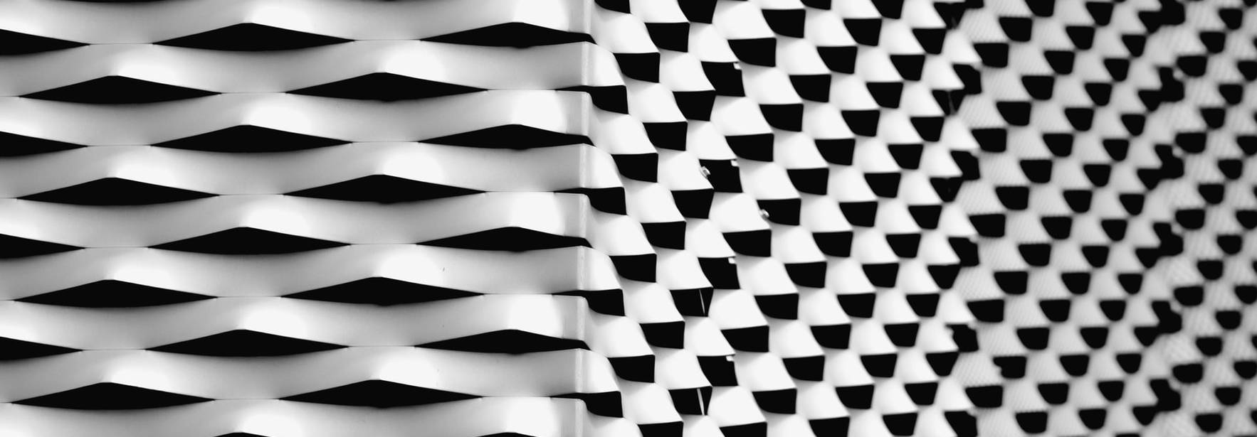 Patrón geométrico en blanco y negro que crea un efecto de ondulación.