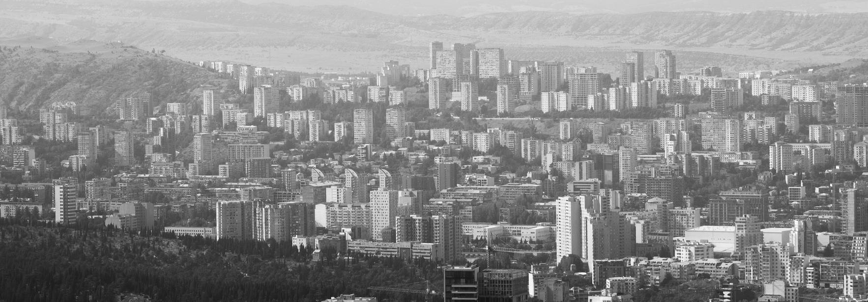 Una vista panorámica de una ciudad moderna rodeada de montañas.