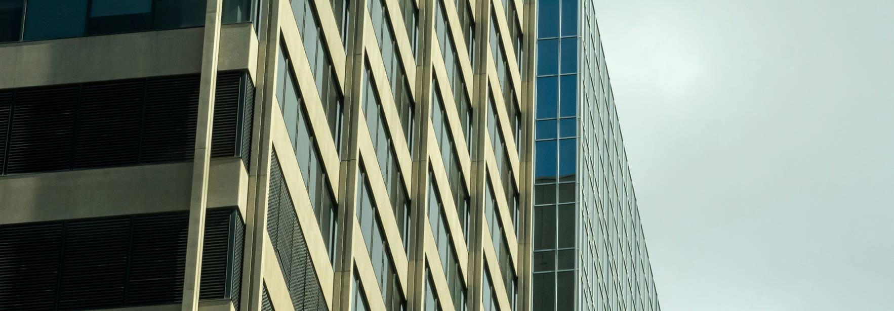 La imagen muestra dos edificios modernos con distintos estilos arquitectónicos.