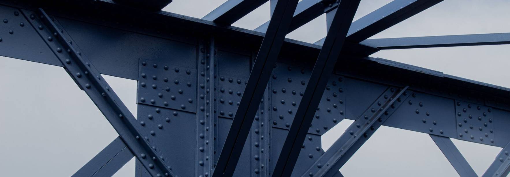 Estructura de un puente con vigas de acero y remaches visibles.