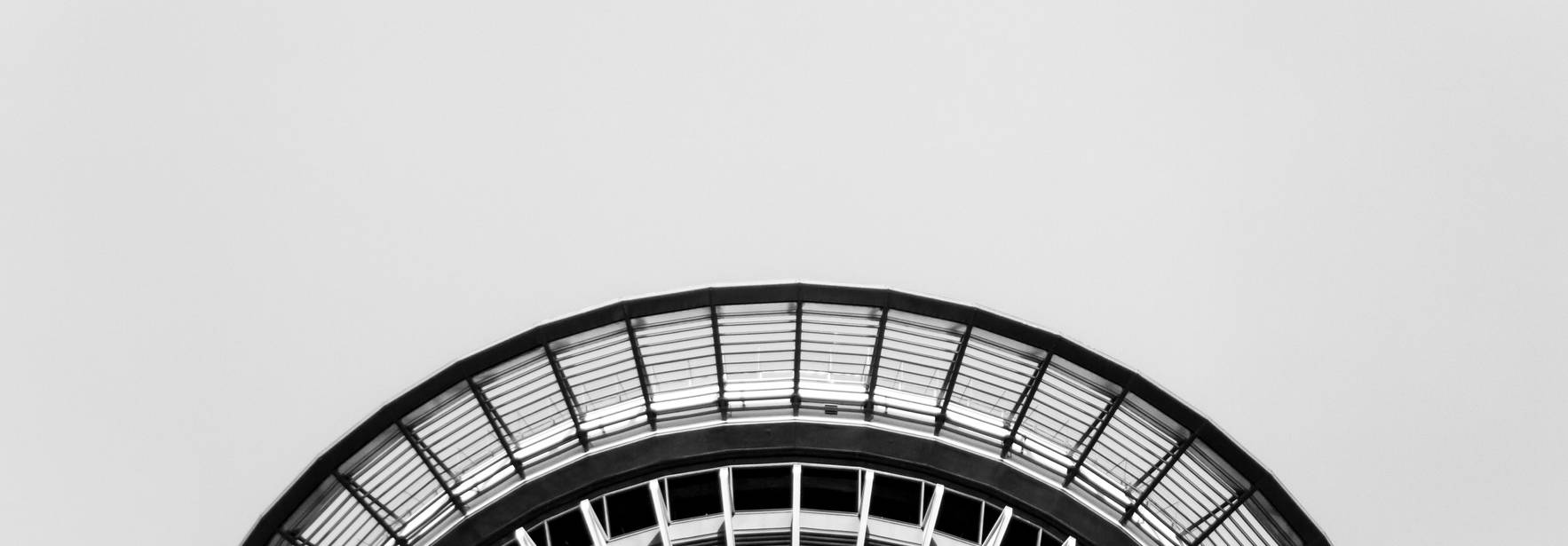La imagen muestra la parte superior de una estructura arquitectónica circular en blanco y negro.