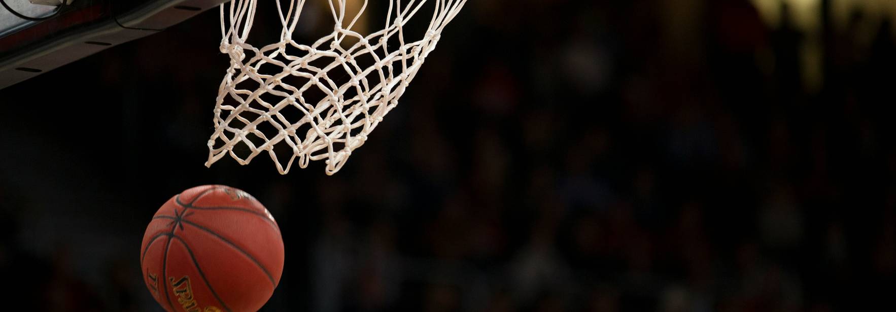 Un balón de baloncesto está a punto de entrar en la canasta.