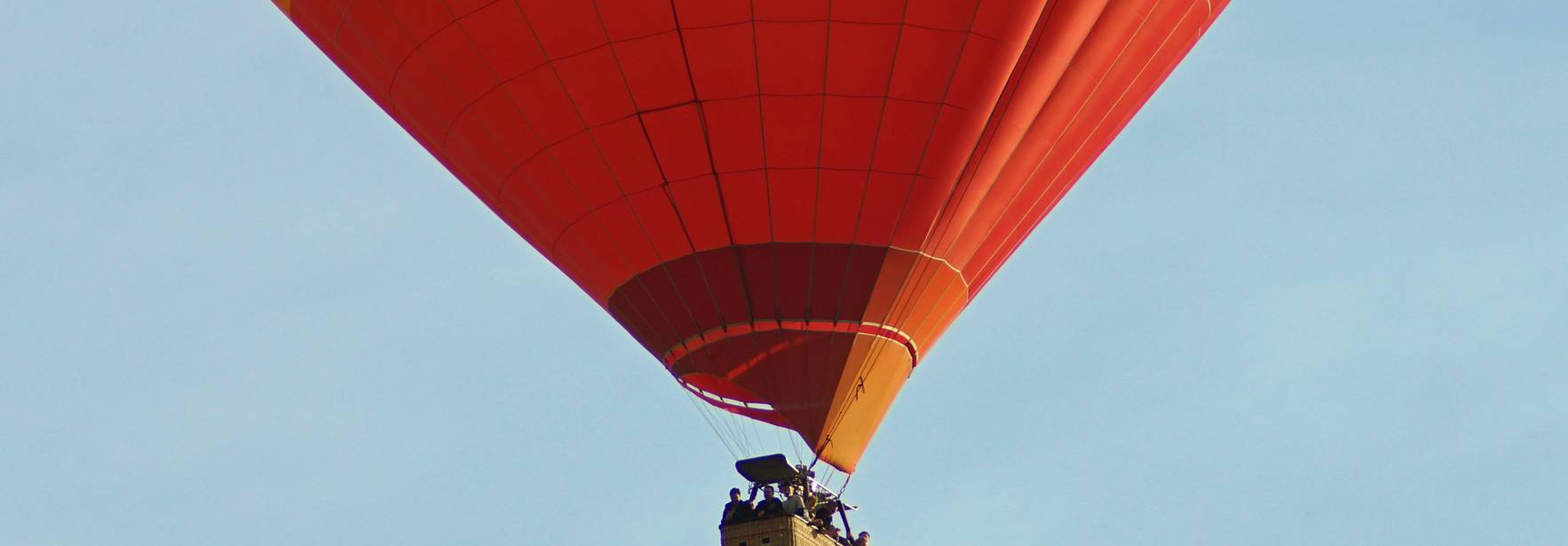 Un globo aerostático colorido asciende por el cielo.