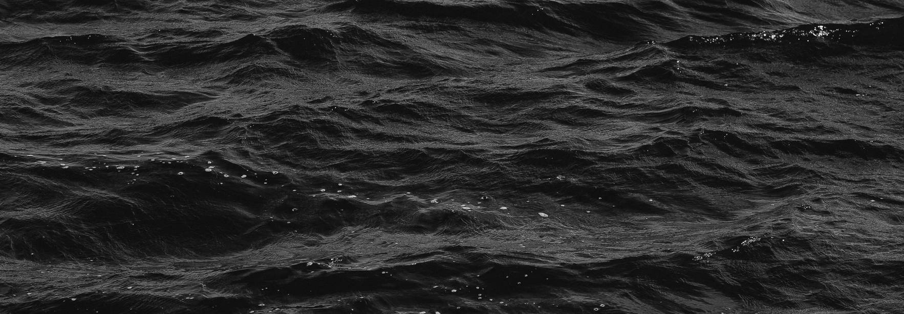 El océano presenta una superficie de olas oscuras y agitadas.