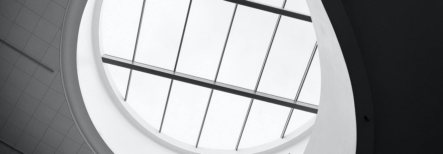 Vista en blanco y negro de una estructura arquitectónica en espiral con un techo de cristal.