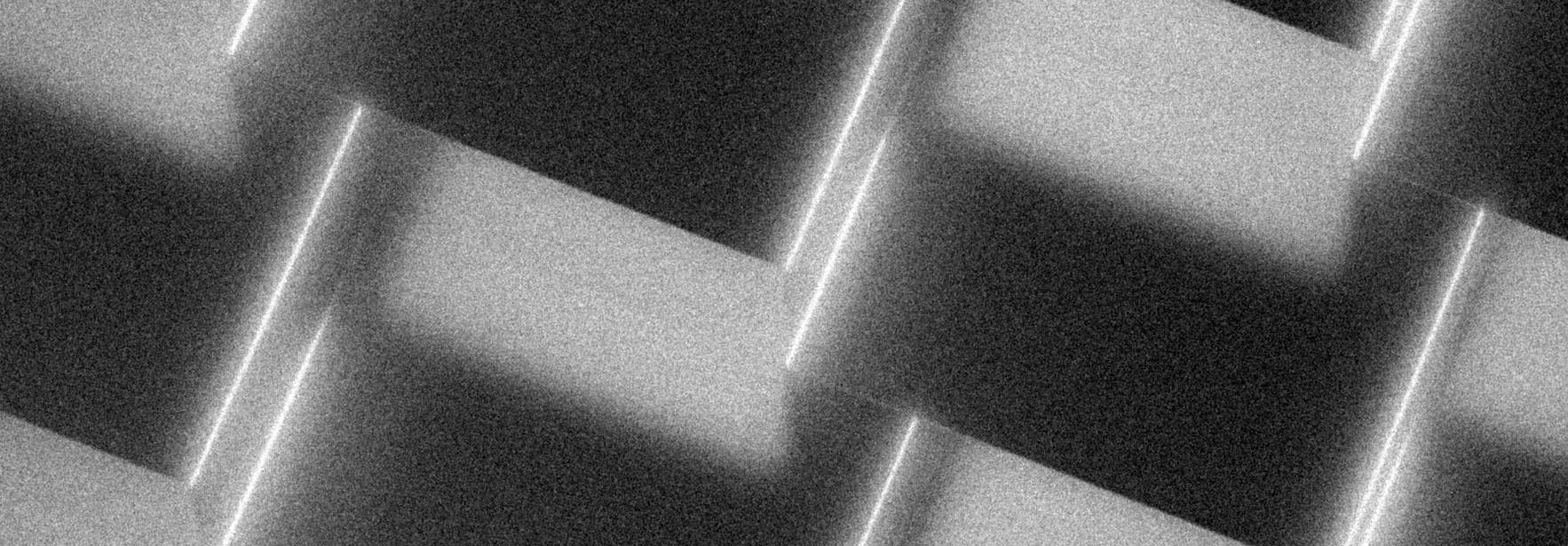 Una textura abstracta en tonos grises con formas geométricas entrelazadas.
