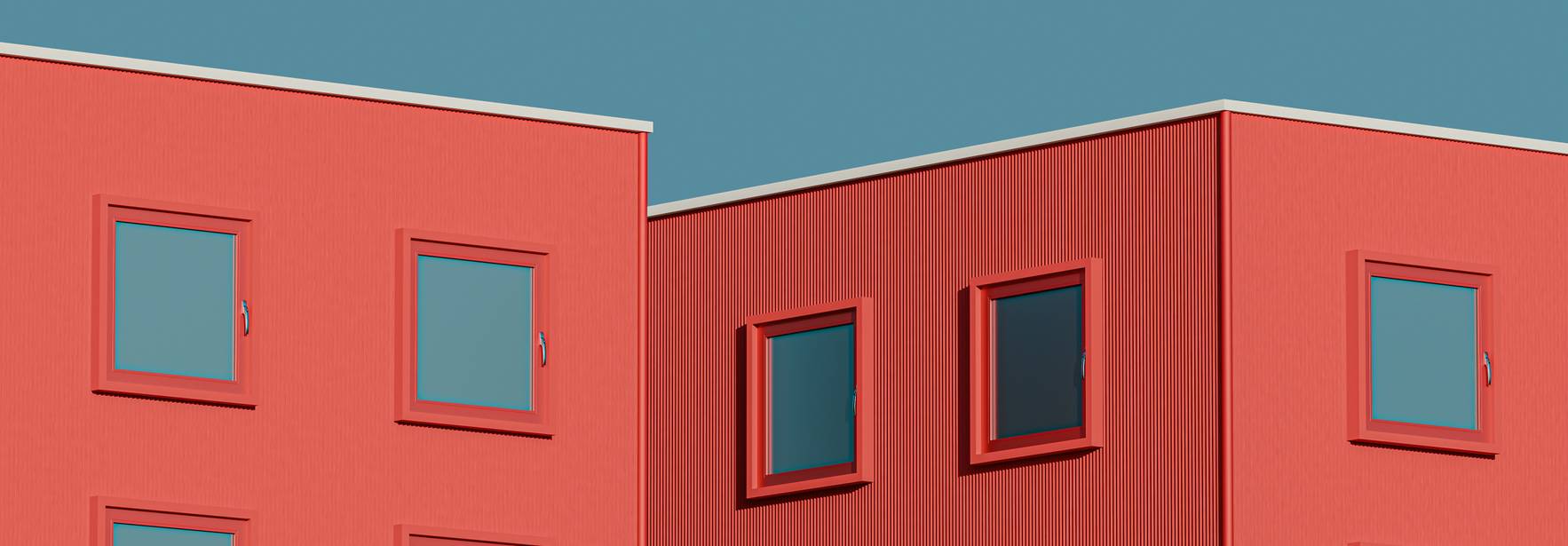 Edificios modernos de color rojo con ventanas cuadradas en un fondo azul.