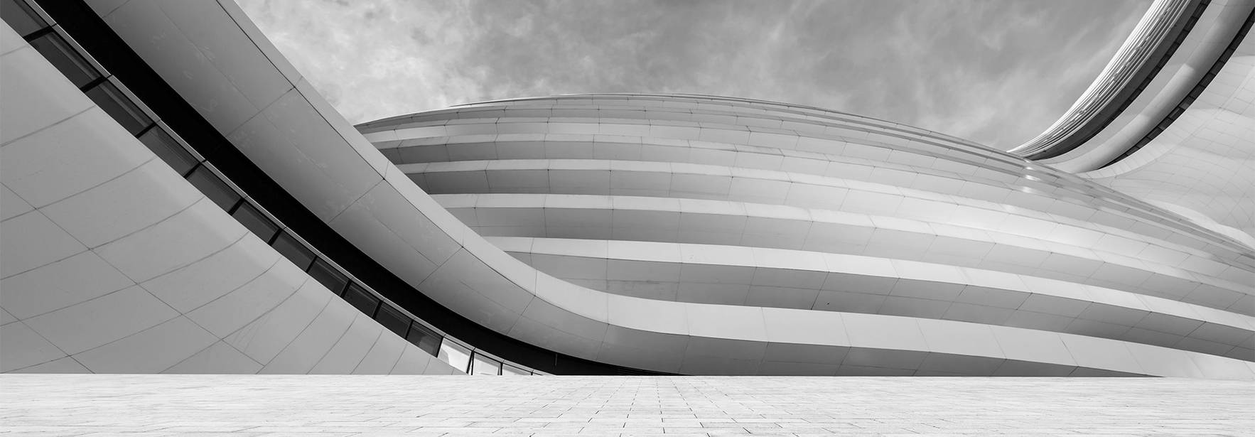 Una imagen en blanco y negro que muestra la arquitectura moderna con líneas curvas y superficies suaves.