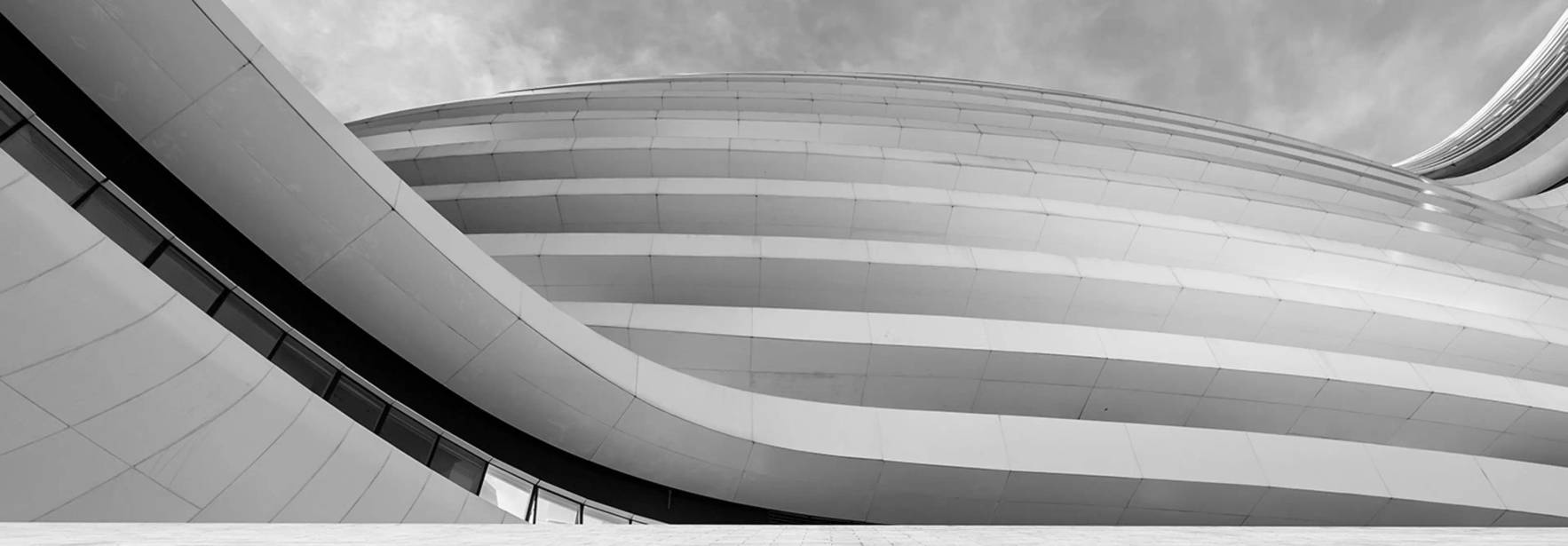 Una imagen en blanco y negro que muestra la arquitectura moderna con formas curvas y líneas elegantes.