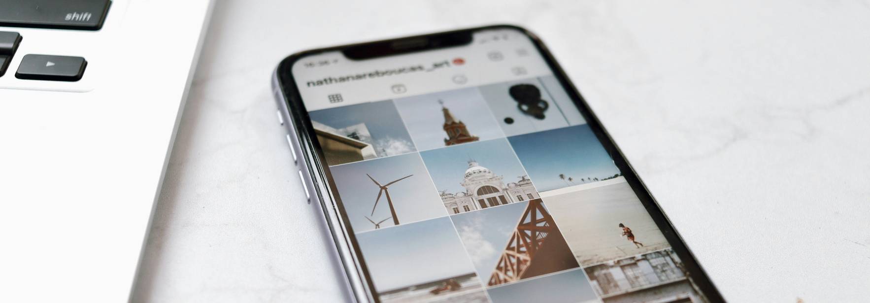 Una imagen que muestra un teléfono móvil con una pantalla de Instagram y una laptop al lado.