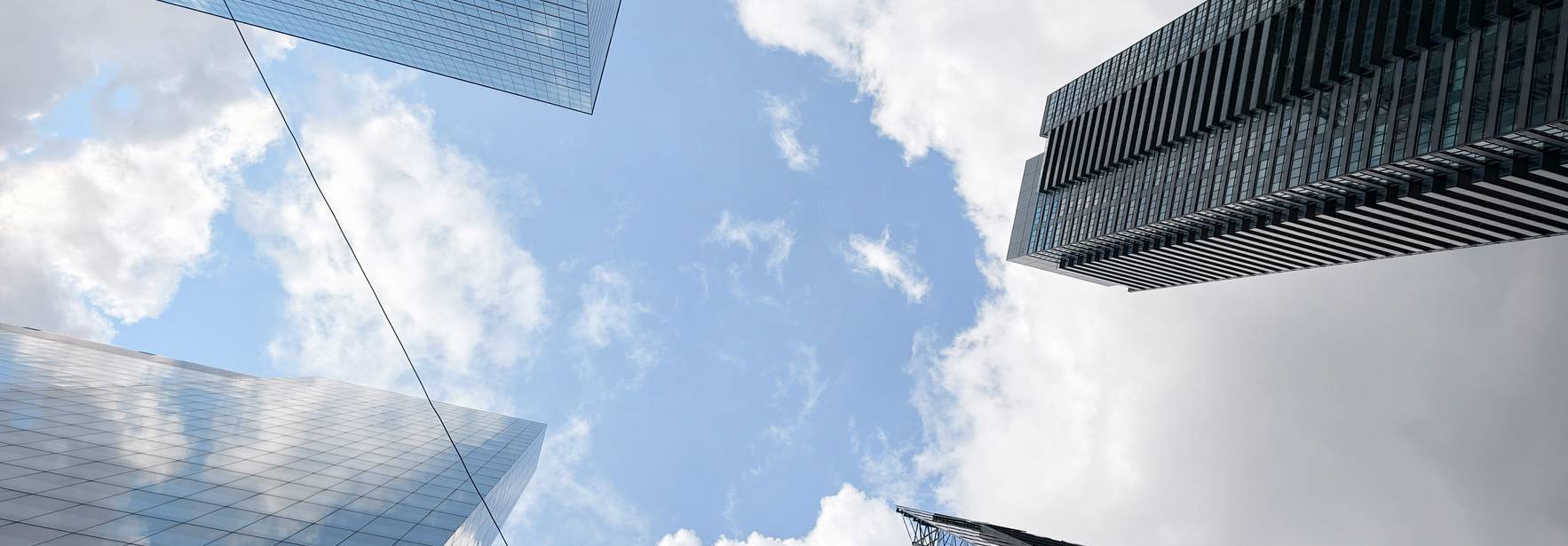 Vista hacia arriba de un grupo de edificios modernos bajo un cielo nublado.