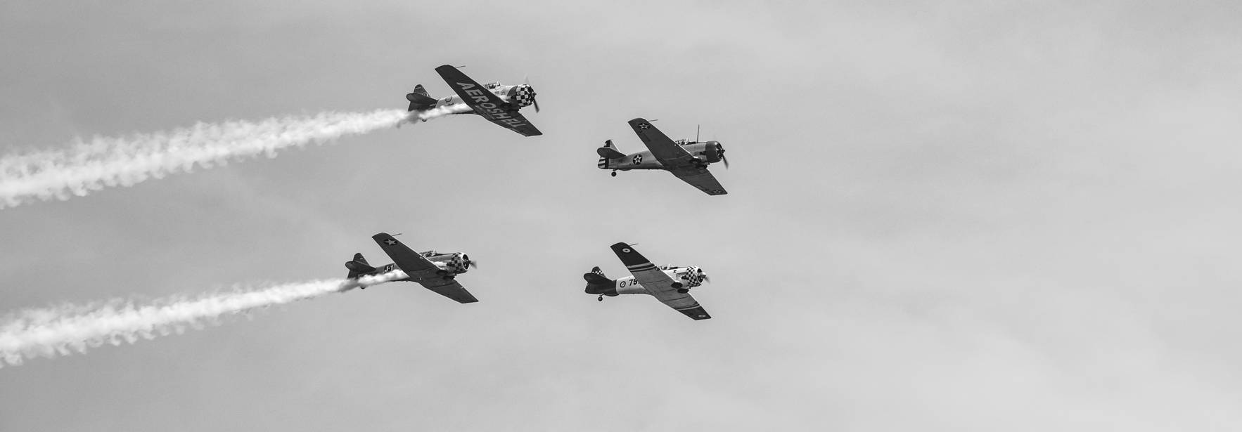 Cuatro aviones realizan formaciones en el cielo mientras dejan estelas de humo.