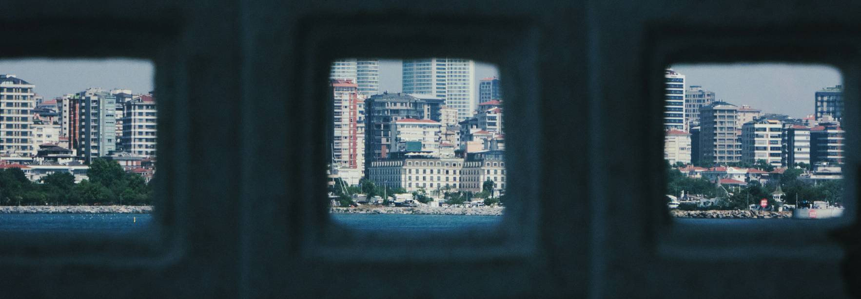 Vista de un paisaje urbano a través de un muro con aberturas.