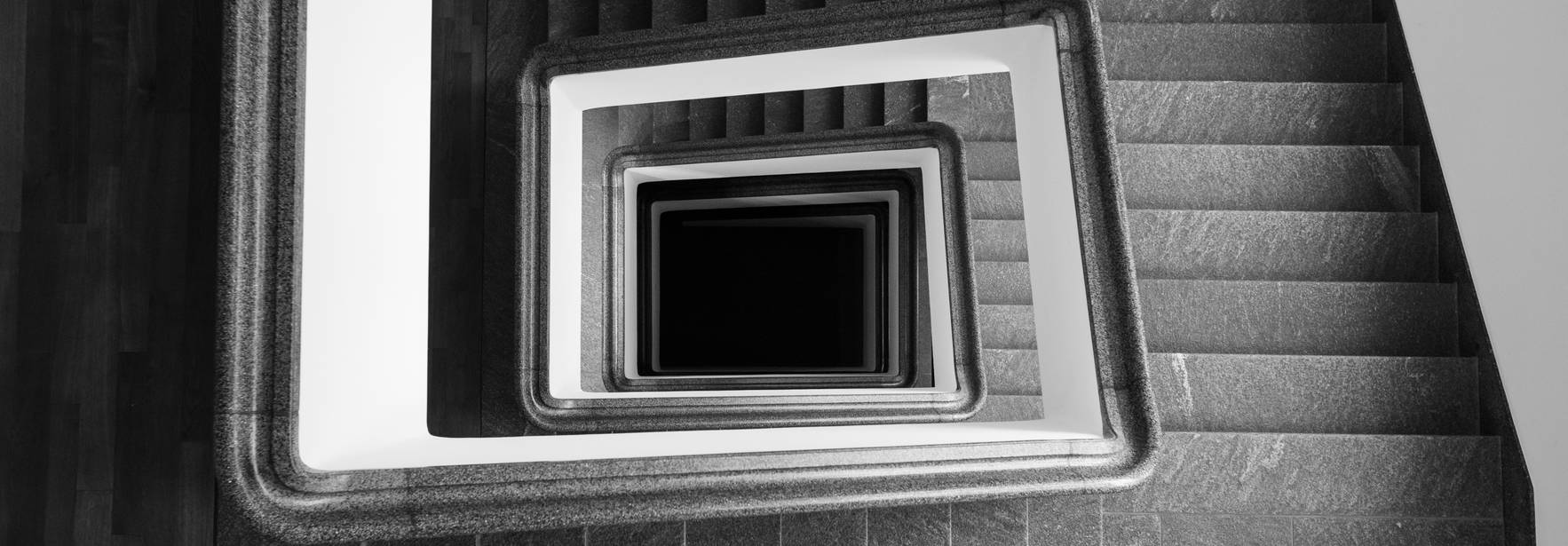 Una imagen en blanco y negro que muestra una escalera en espiral desde una vista aérea.