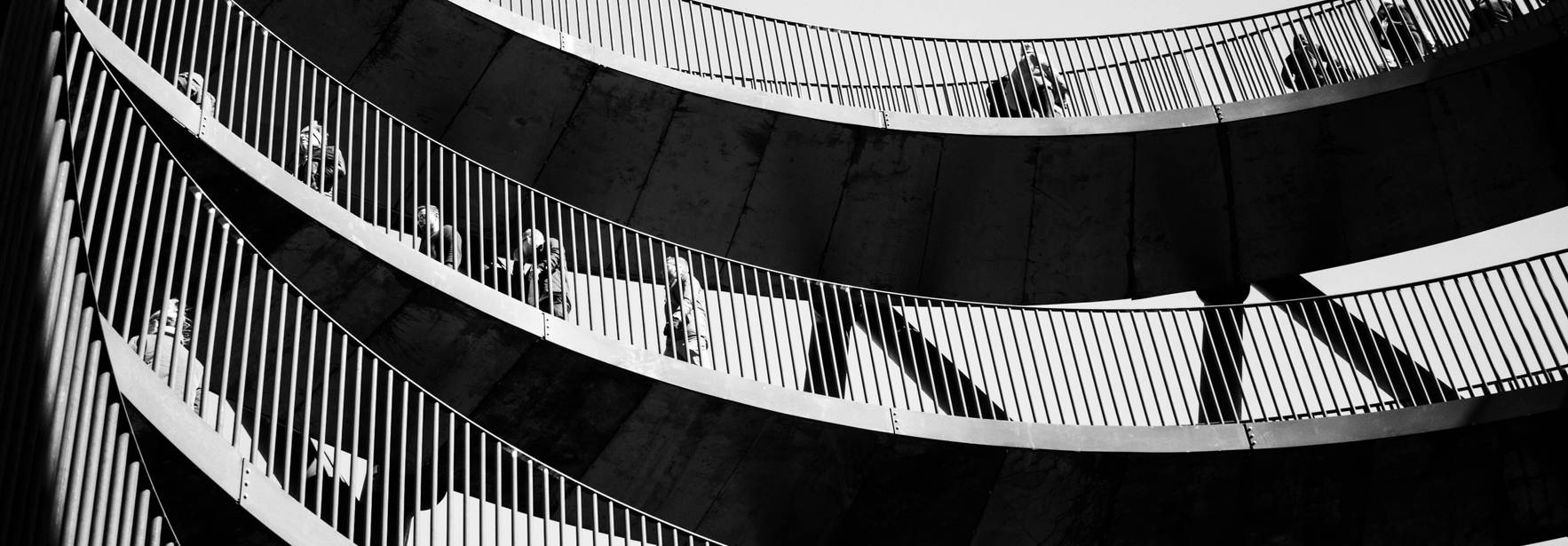 Una escalera en espiral con personas caminando en diferentes niveles.