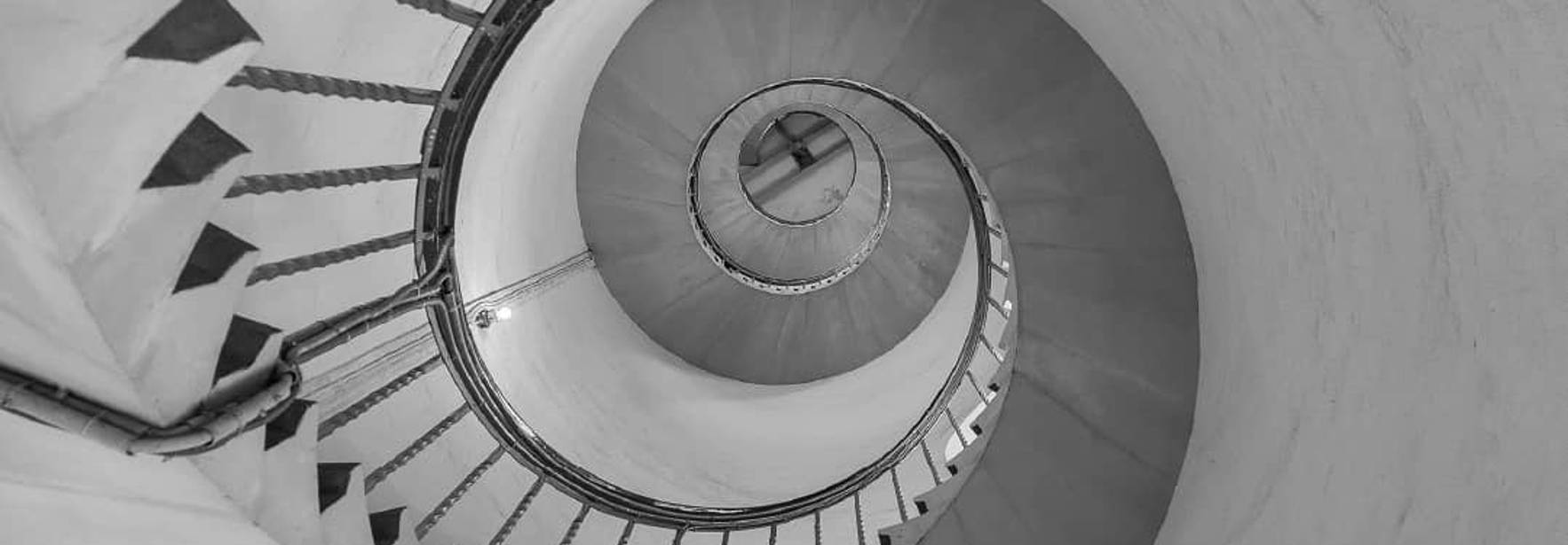 Una escalera en espiral que desciende hacia el centro de una estructura.