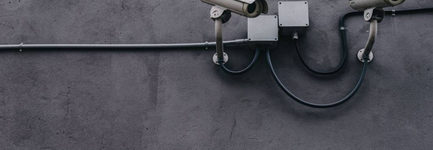 Dos cámaras de seguridad están montadas en la pared exterior de un edificio.