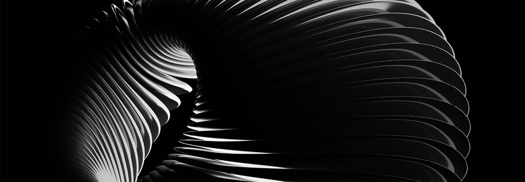 La imagen muestra una estructura en forma de espiral con estrías, en blanco y negro, que evoca una sensación de movimiento y fluidez.