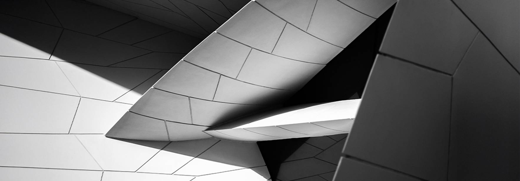 Imagen en blanco y negro que muestra una serie de formas geométricas angulares y líneas en un diseño arquitectónico moderno.