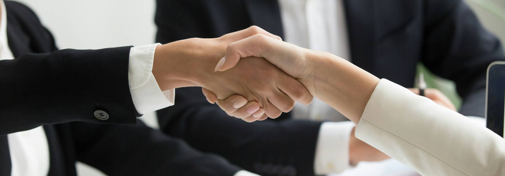 Dos personas se estrechan la mano en un entorno de oficina.