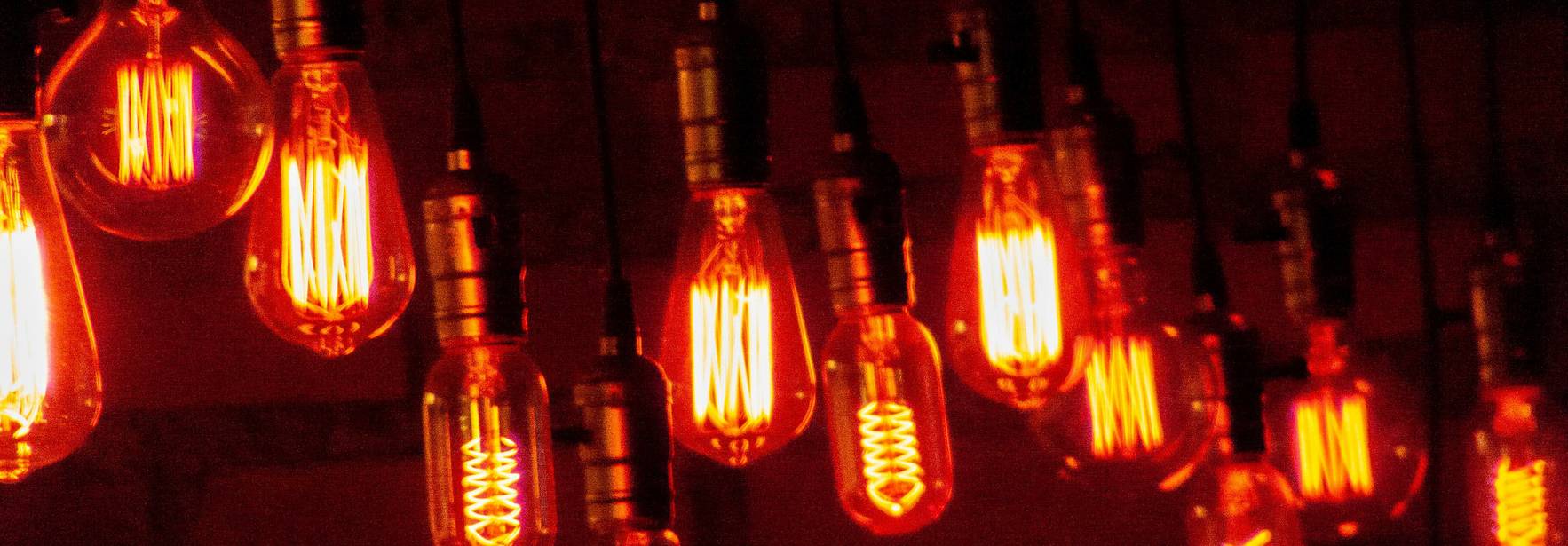 Una serie de bombillas de luz cálida colgadas, emitiendo un brillo anaranjado intenso.