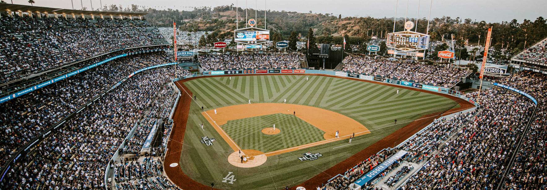 Vista panorámica de un estadio de béisbol lleno de espectadores durante un partido.