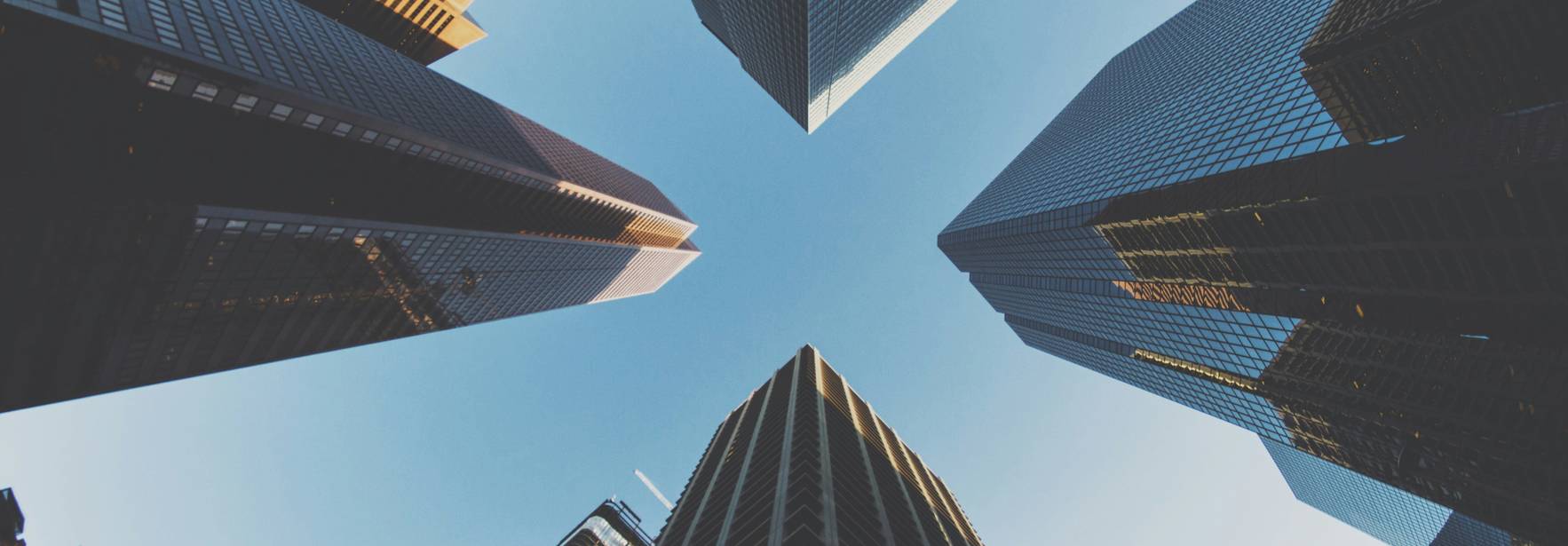 Una vista desde abajo de altos edificios que se alzan hacia el cielo.