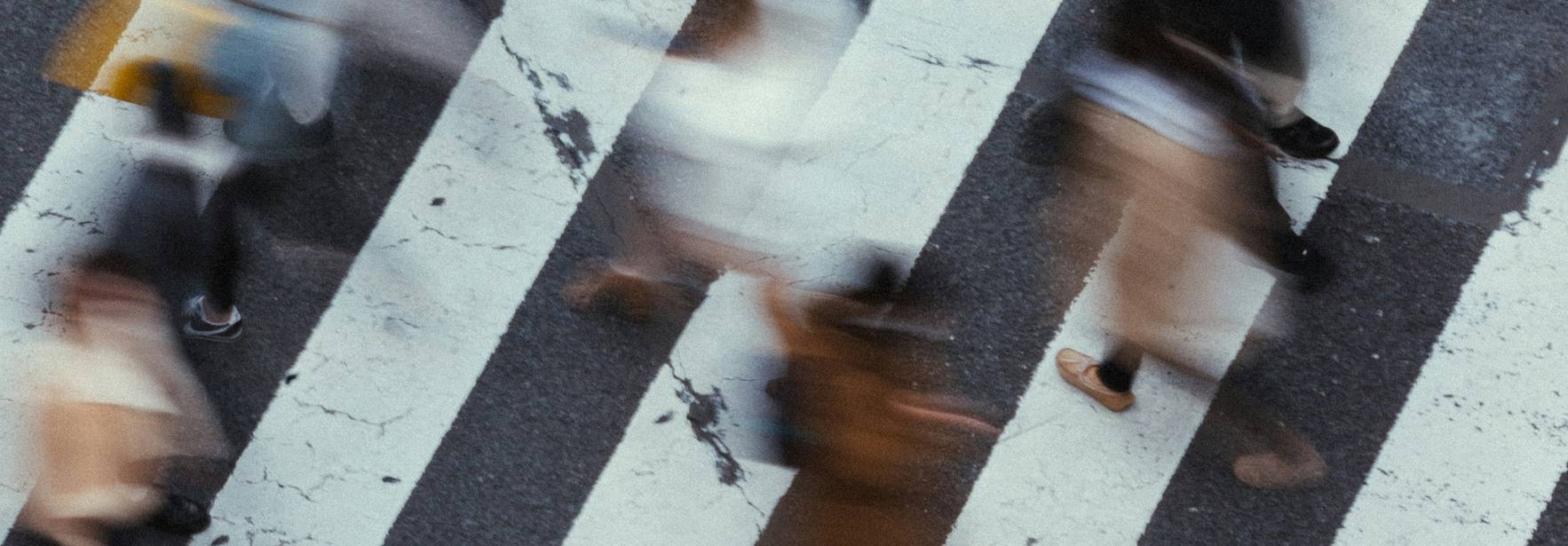 Una multitud de personas cruzando una calle en un paso peatonal.