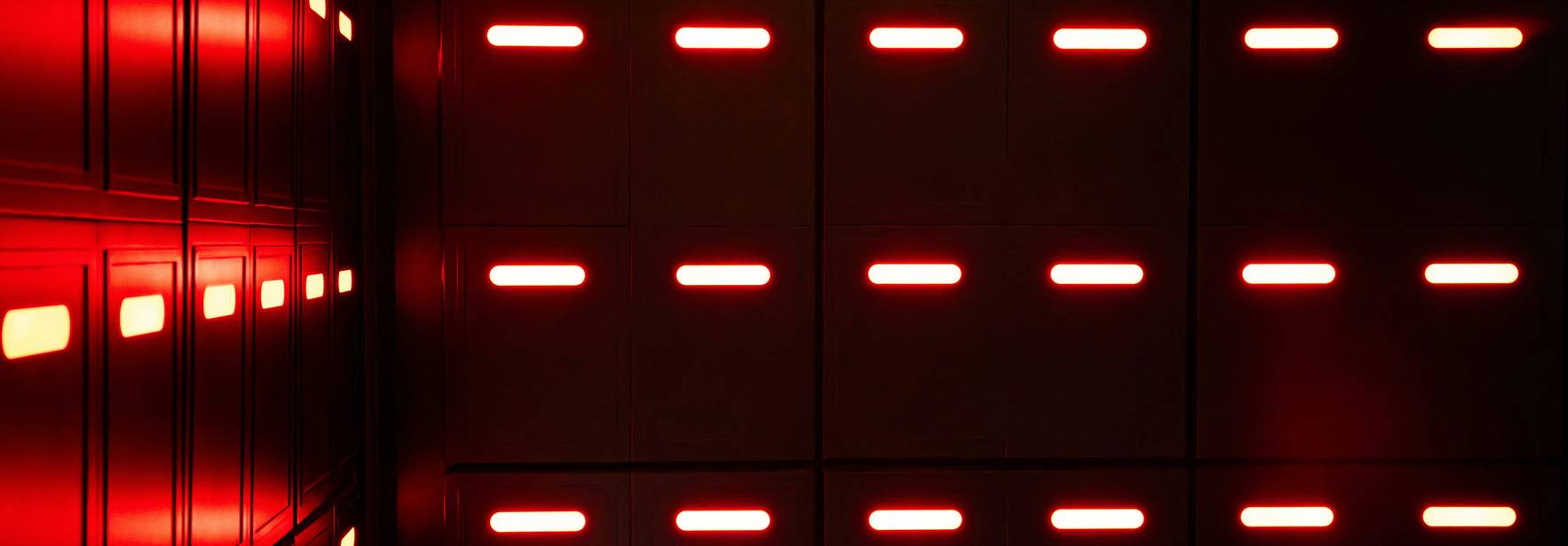 La imagen muestra una serie de paneles con luces rojas en un ambiente oscuro.