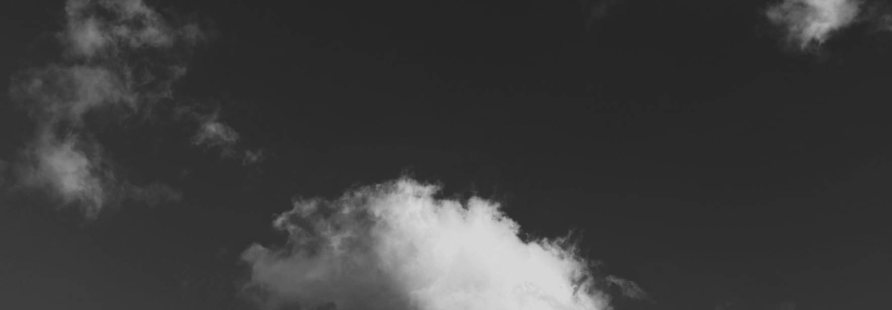 Una nube blanca se destaca en un cielo oscuro.