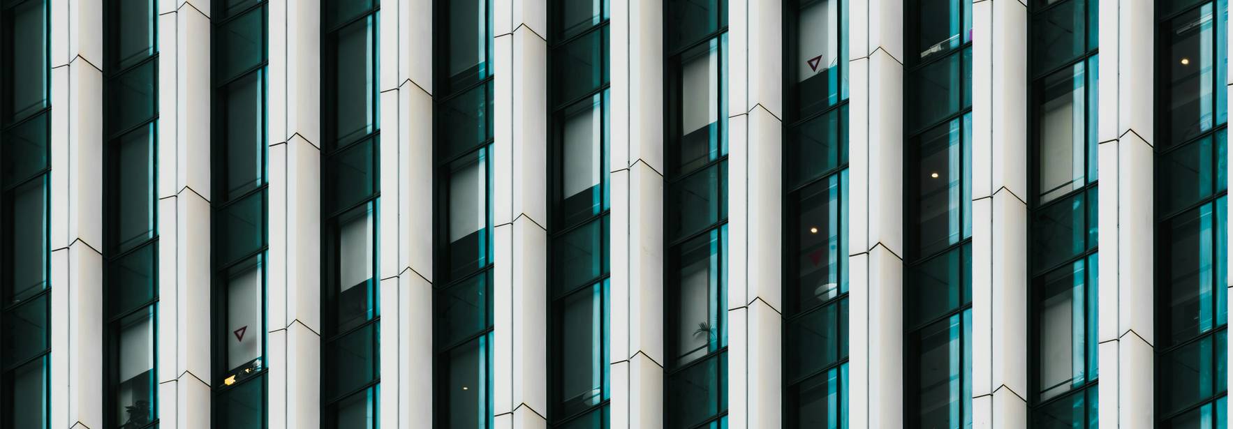 Primer plano de una fachada de un edificio moderno con patrones geométricos en cristal y metal.
