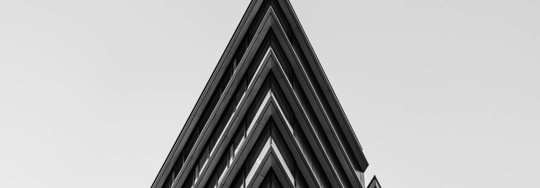 Una vista en ángulo de un edificio moderno que muestra su diseño arquitectónico en blanco y negro.