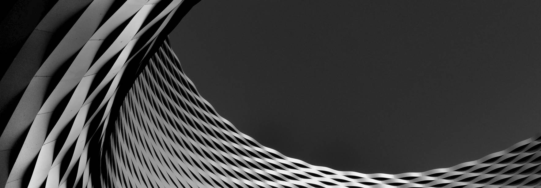Una vista abstracta de una estructura arquitectónica con patrones en blanco y negro.