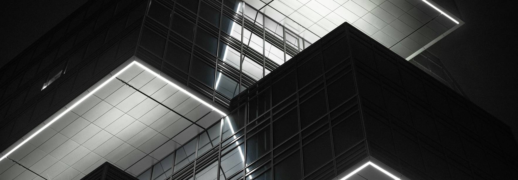 Edificio moderno iluminado en la oscuridad con un diseño arquitectónico innovador.