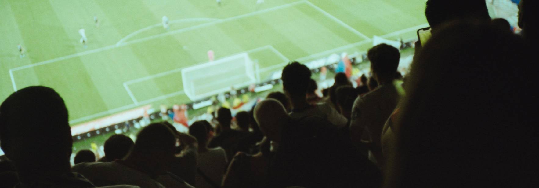 Una multitud de aficionados se encuentra viendo un partido de fútbol en un estadio.