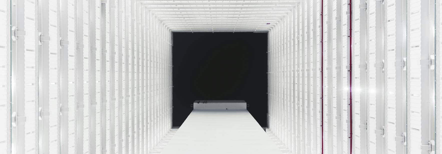 Una imagen que muestra una estructura blanca con un fondo negro, creando una sensación de profundidad y simetría.